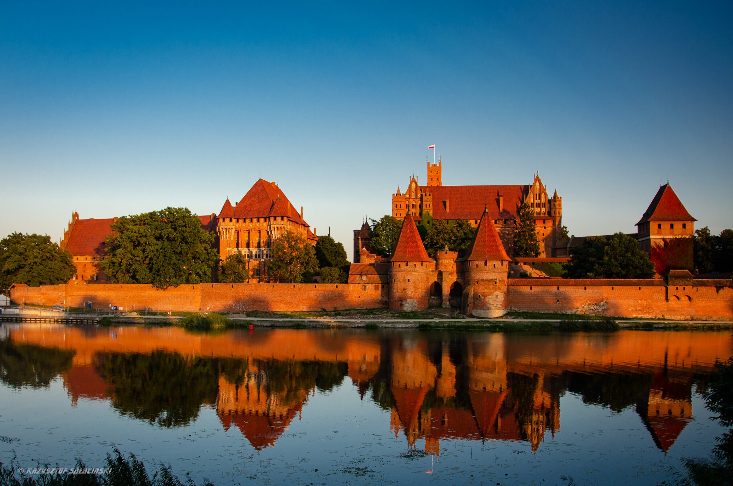 Malbork Castle at sunset reflected in the Nogat river